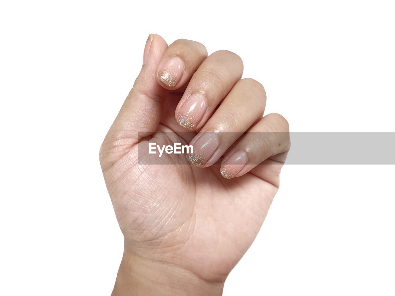 CLOSE-UP OF PERSON HAND AGAINST GRAY BACKGROUND