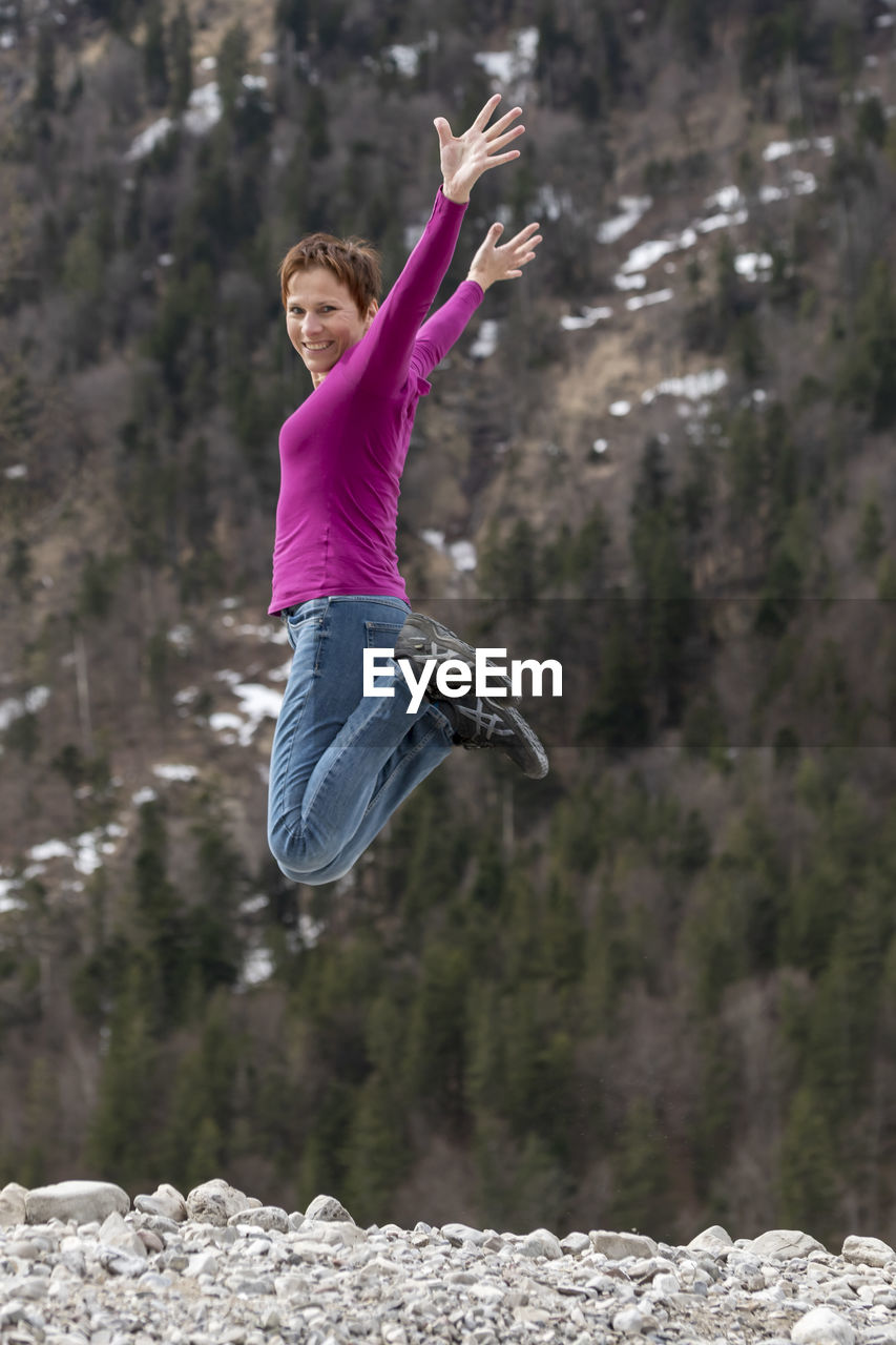 Portrait of woman jumping on land