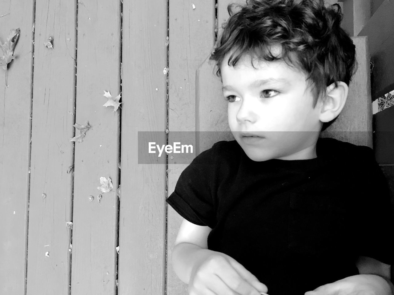 Close-up of boy lying on wooden floor