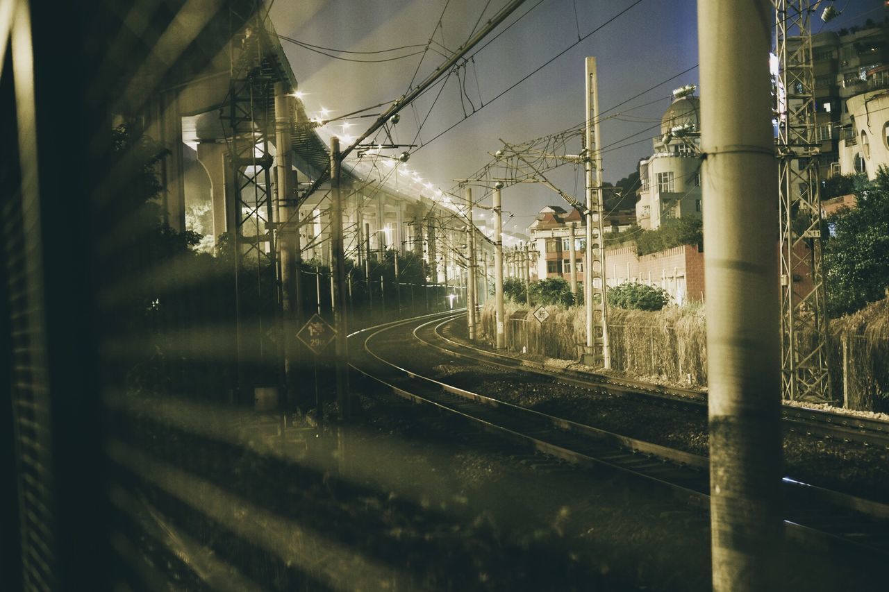 Railroad tracks by buildings seen from train window