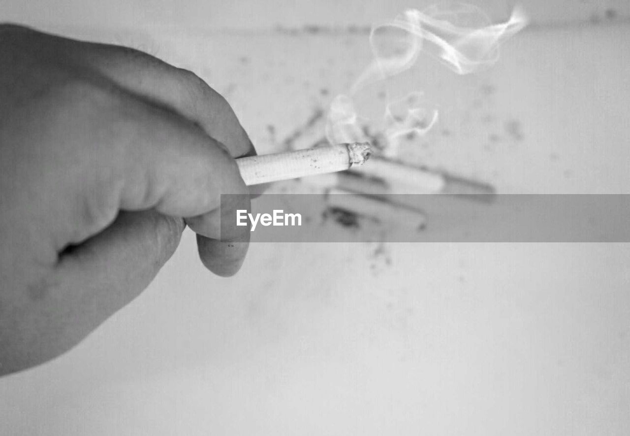 Close-up of hand holding cigarette