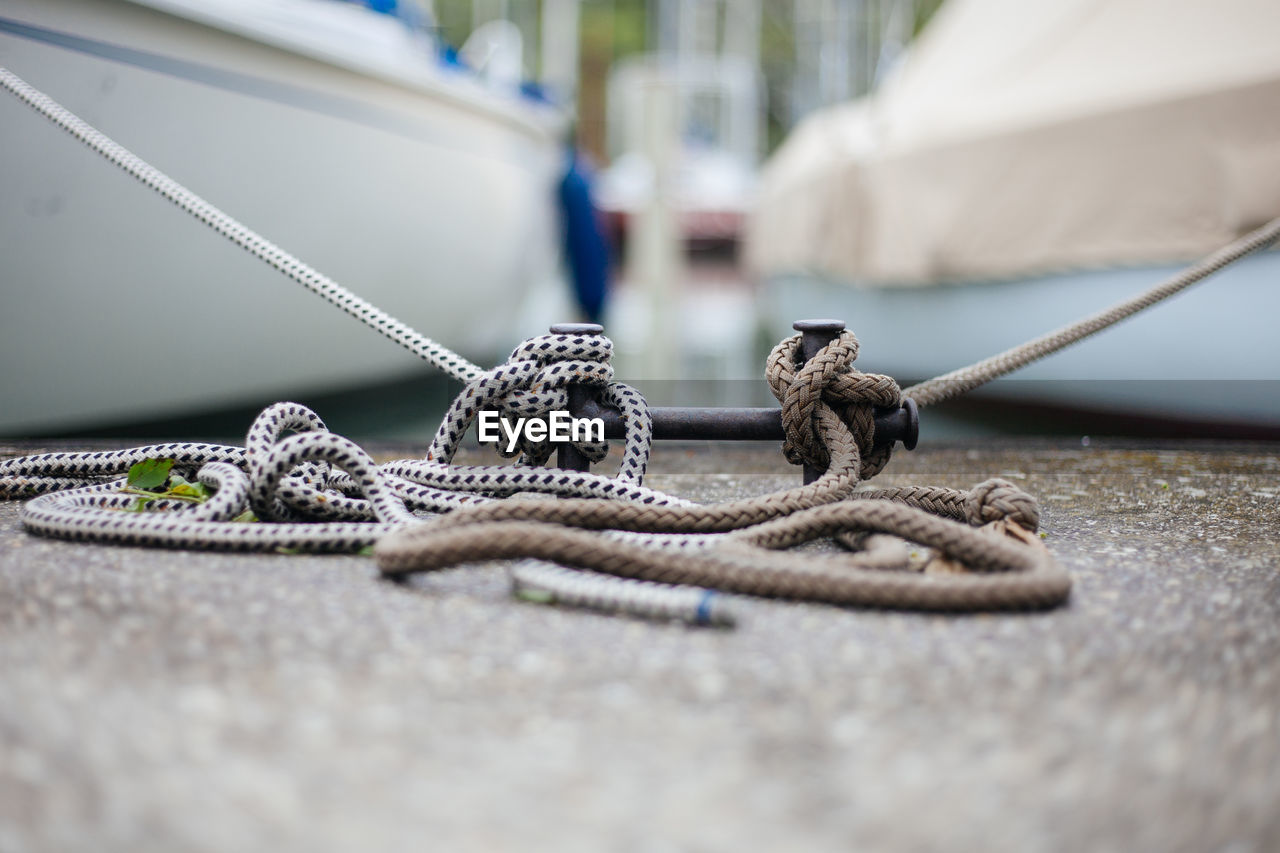 CLOSE-UP OF ROPE TIED TO METAL