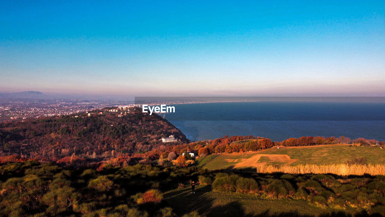 HIGH ANGLE VIEW OF LAND AND SEA AGAINST SKY