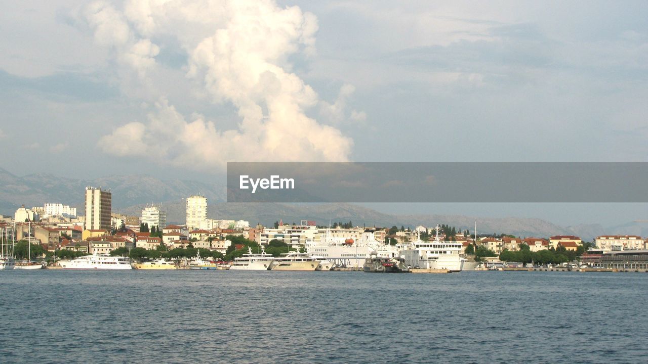 BUILDINGS BY SEA AGAINST SKY IN CITY