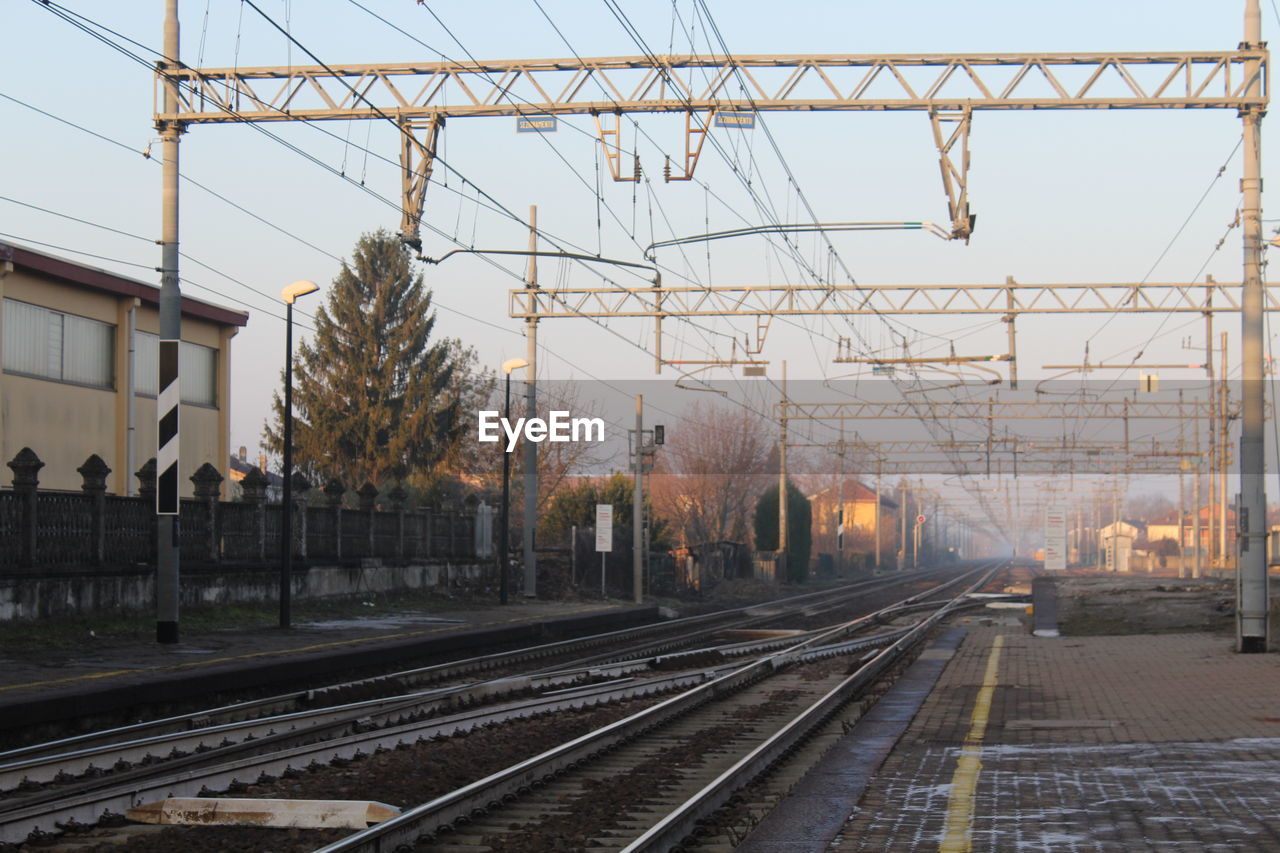 RAILROAD TRACKS AGAINST CLEAR SKY AT STATION