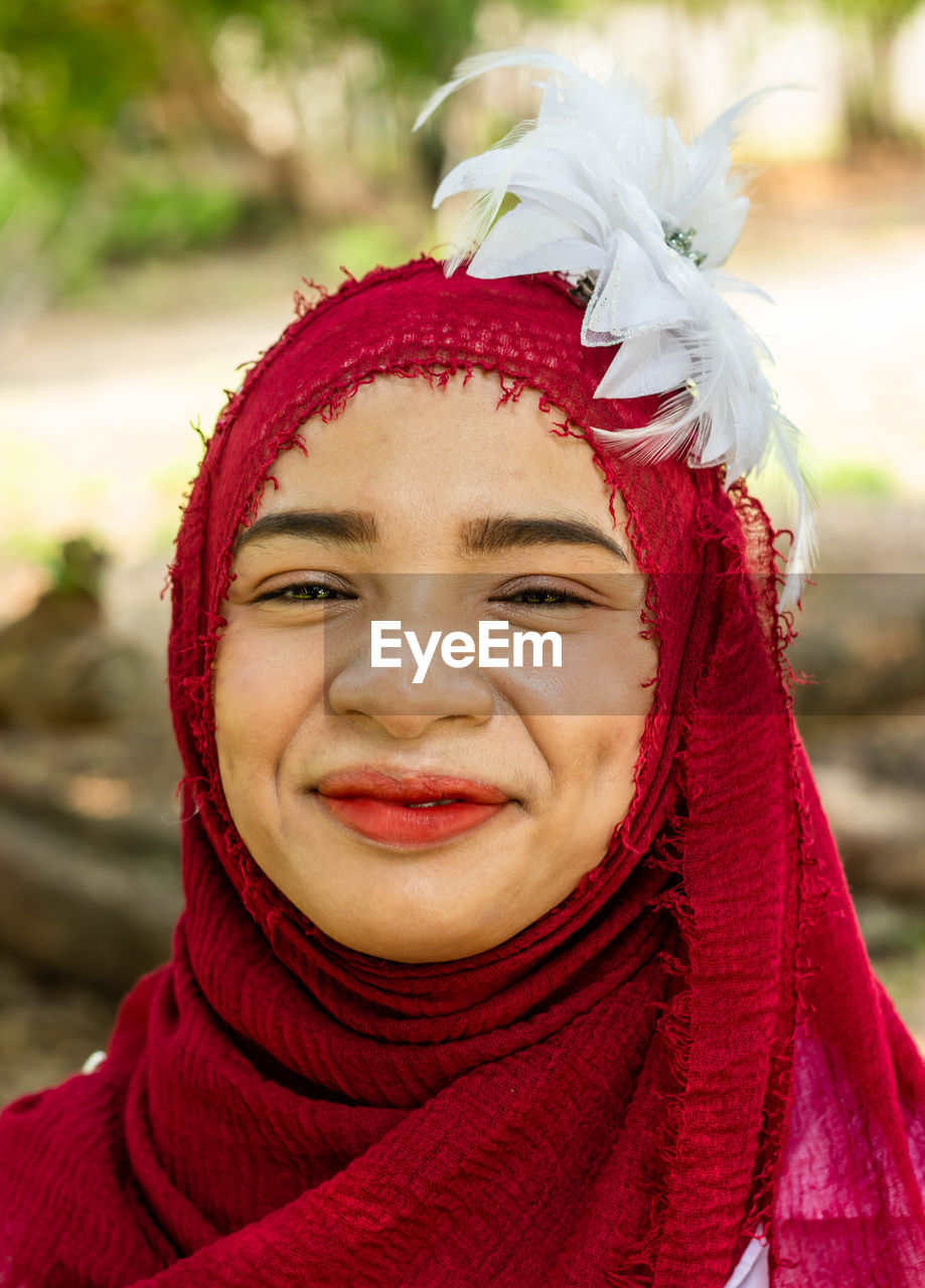 Young woman wearing red hijab in public park
