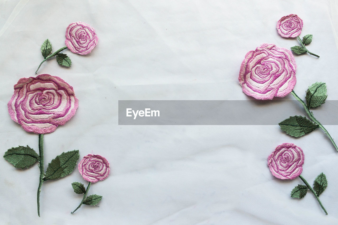 HIGH ANGLE VIEW OF ROSES IN VASE ON WHITE TABLE