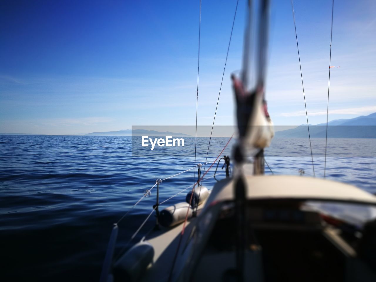 Close-up of sailboat sailing on sea against sky
