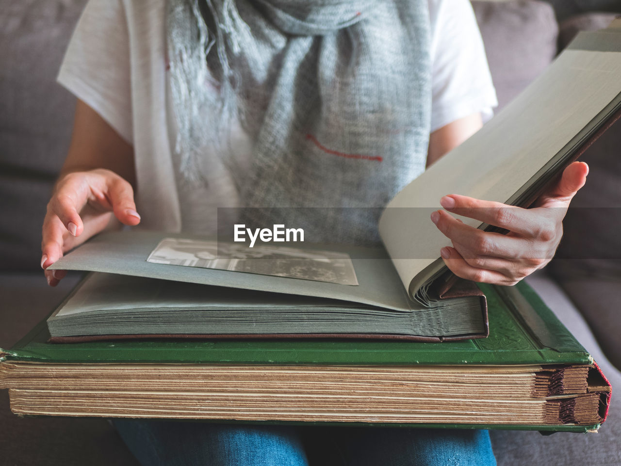 Huge photo albums in hands of woman. person views photos in old family album