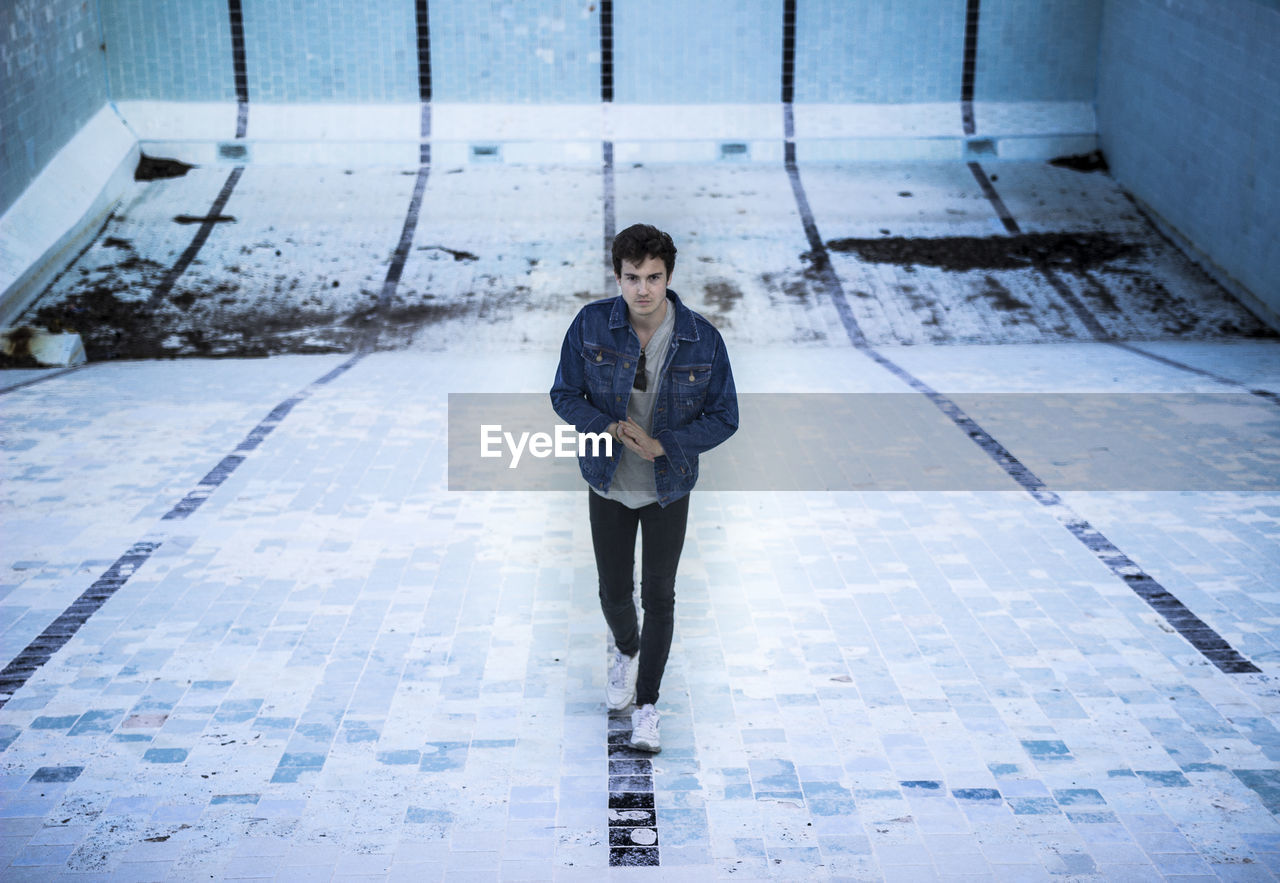 Full length of young man walking on tiled floor