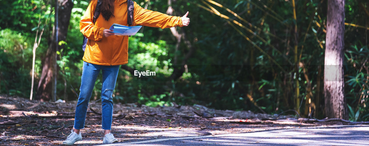 rear view of woman walking on footpath in forest