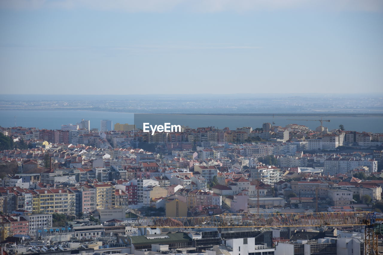 High angle view of townscape by sea against sky