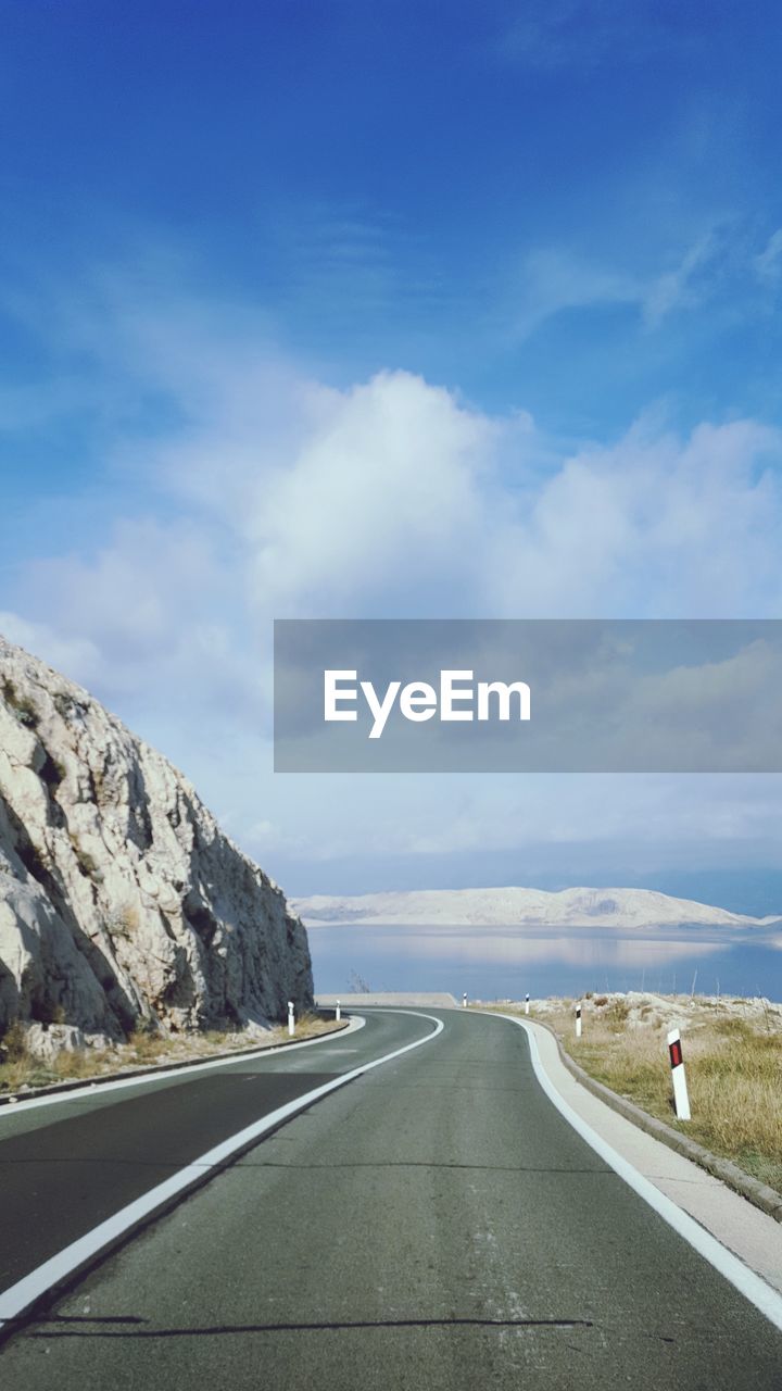 Road by mountain against sky