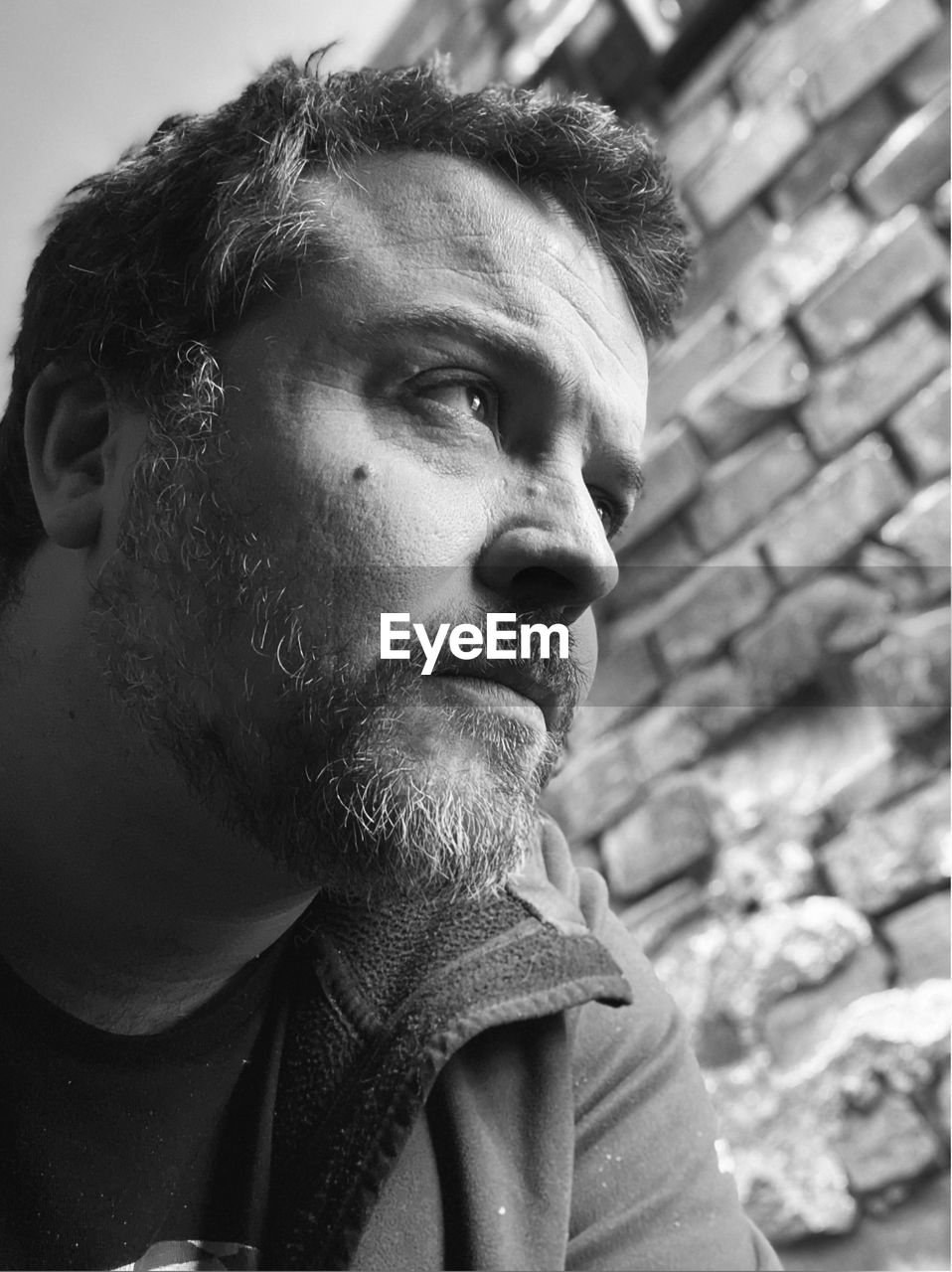 Close-up of man looking away sitting outdoors