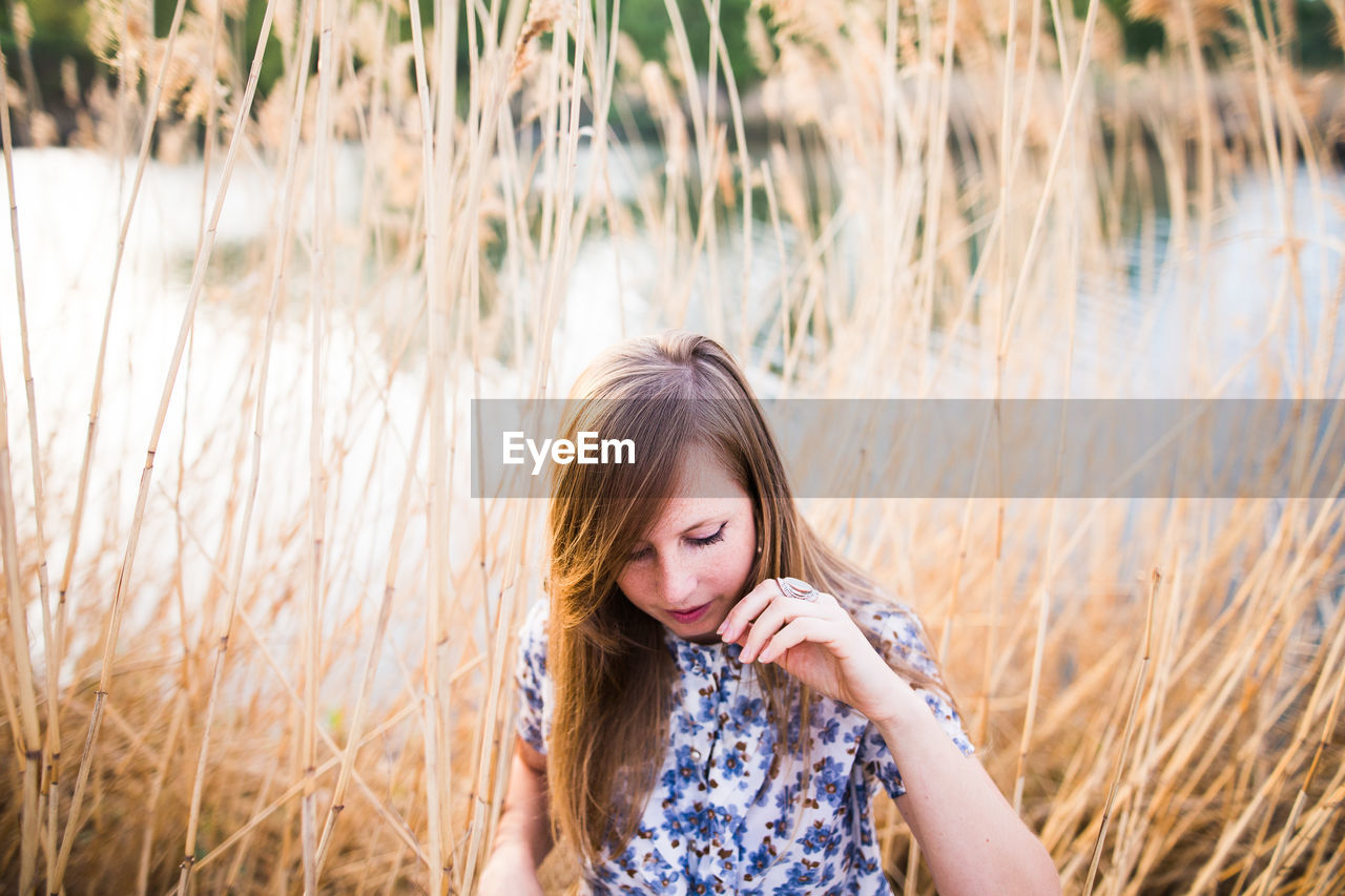 Young woman standing by plants