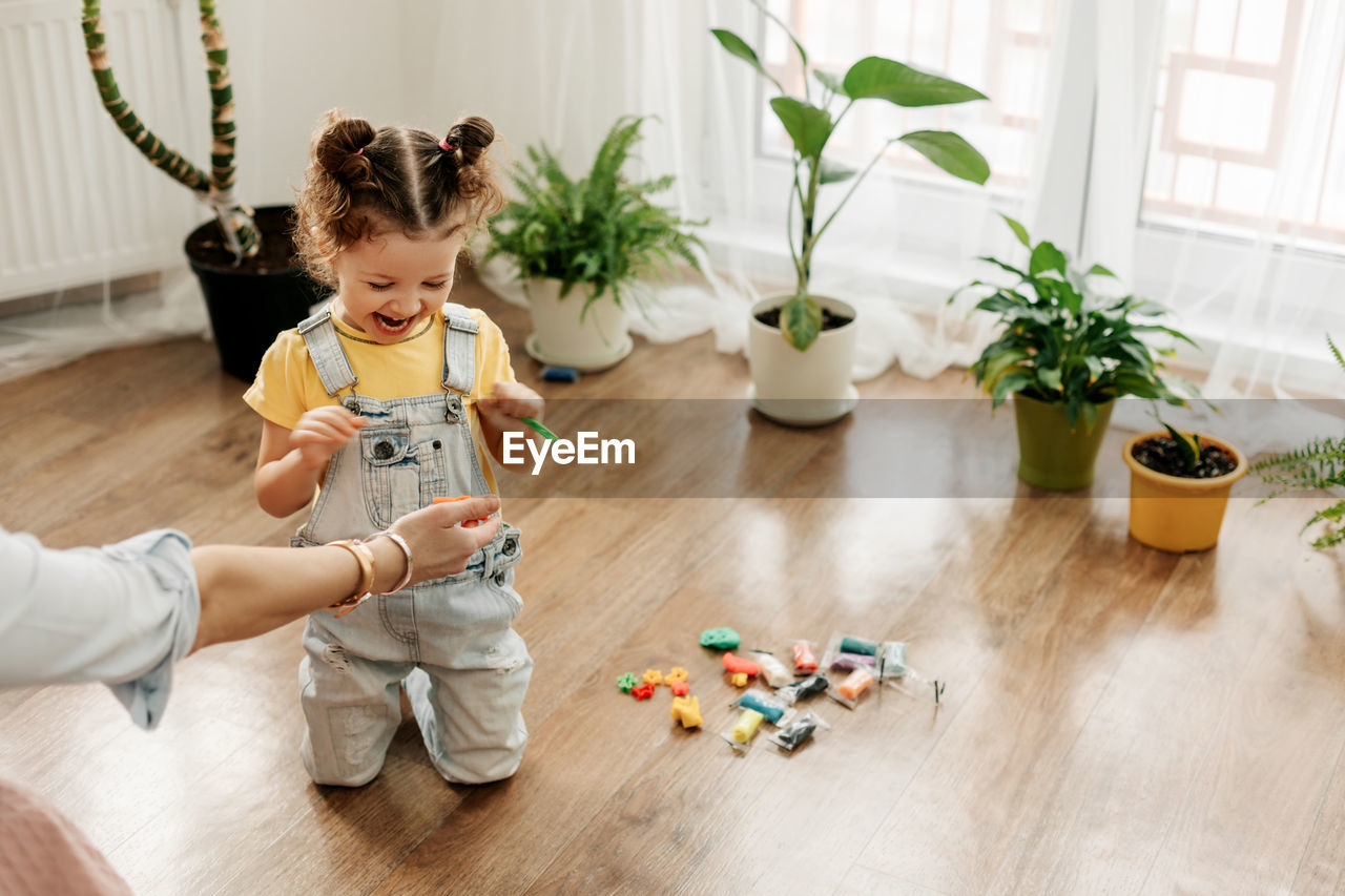 Mom and little daughter choose colorful plasticine for the game. the concept of preschool 