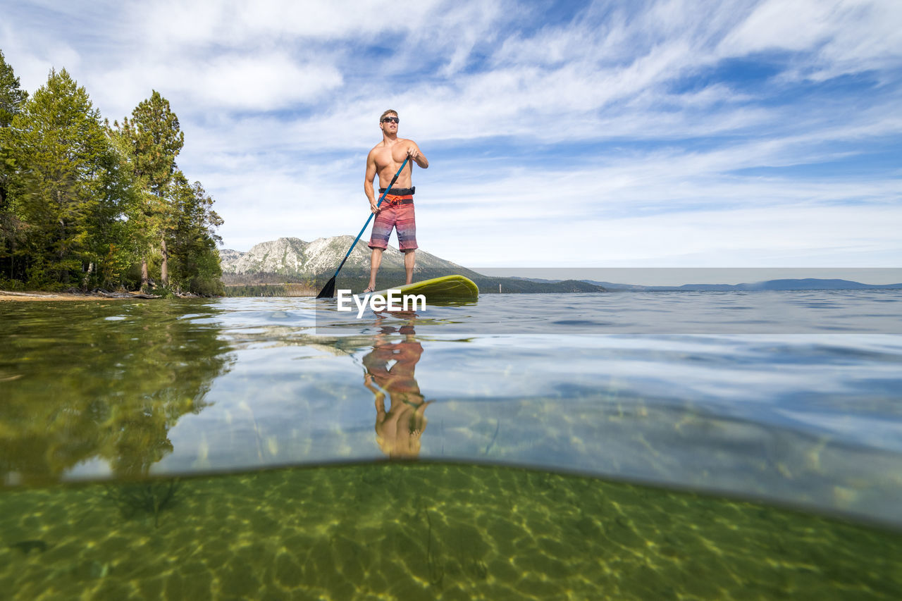 A man stand up paddle boarding on lake tahoe, ca