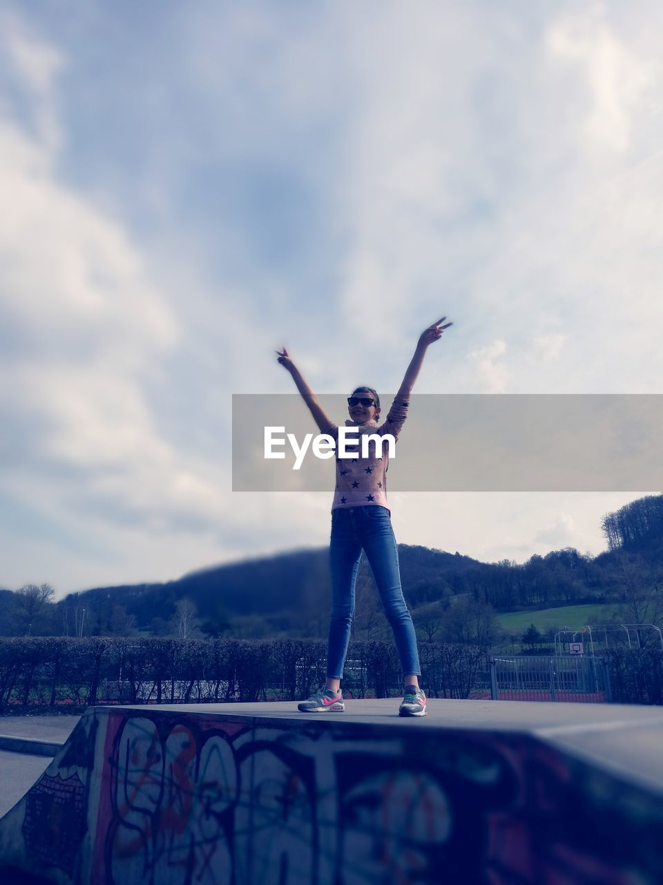 FULL LENGTH OF WOMAN STANDING AGAINST BLUE SKY