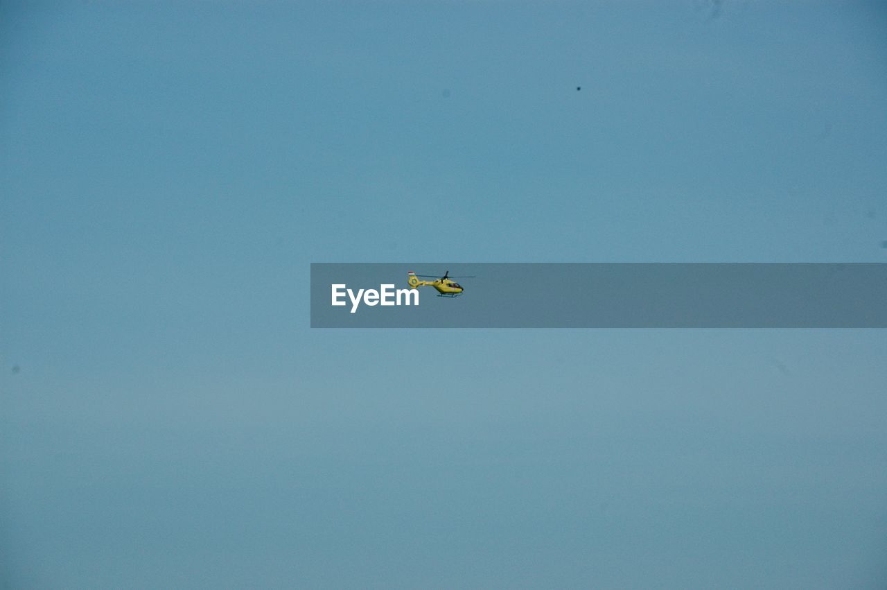 LOW ANGLE VIEW OF KITE FLYING IN BLUE SKY