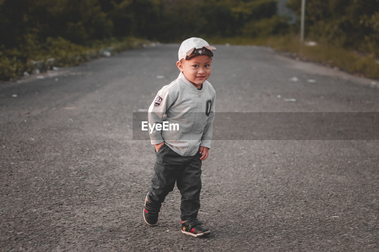 Portrait of toddler boy walking on road