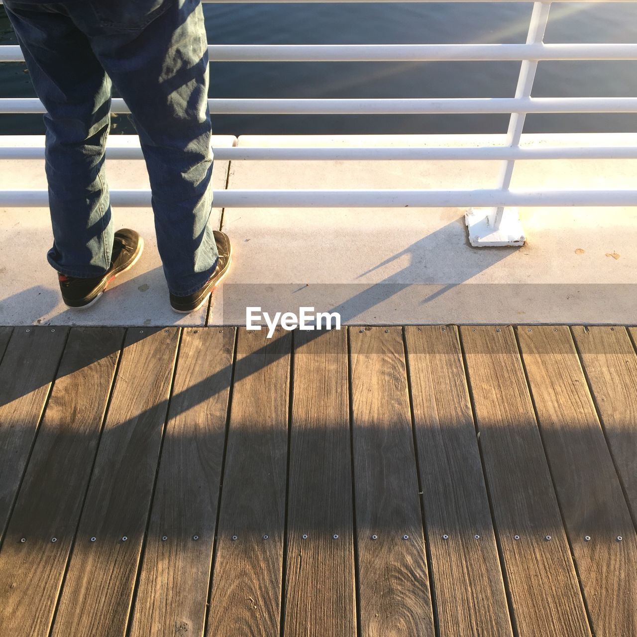Low section of man standing on pier