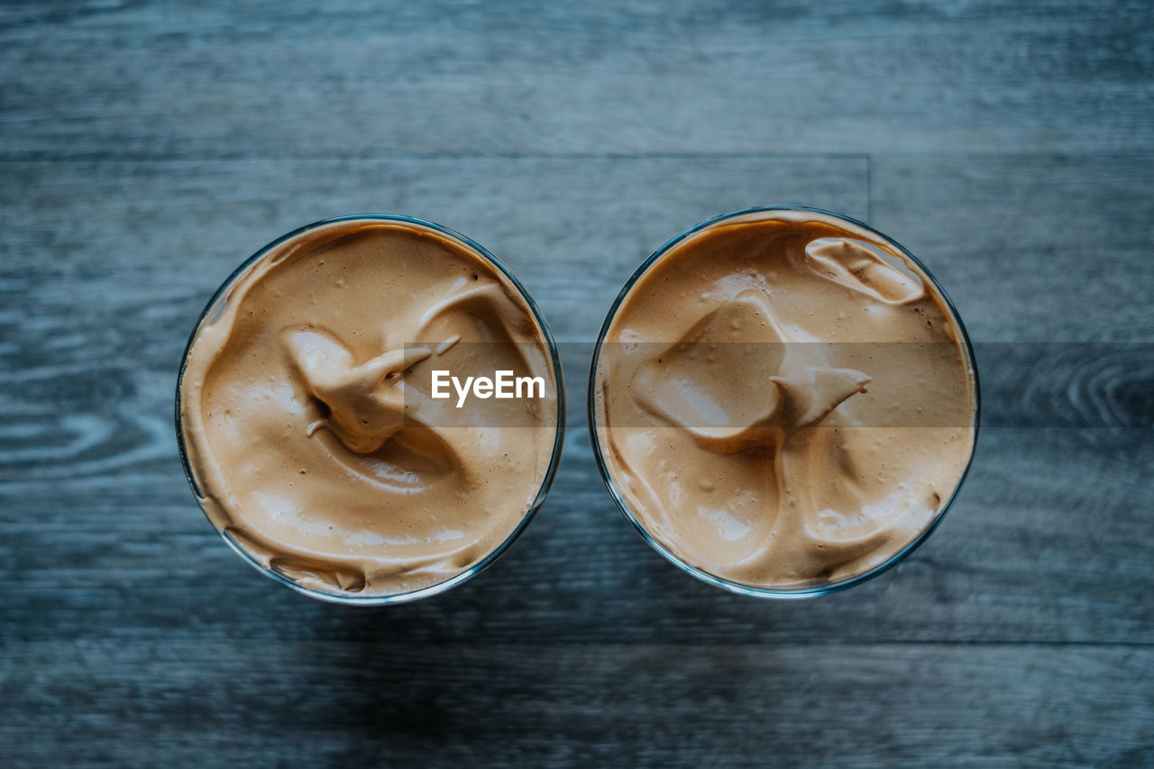 Overhead view of whipped coffee on wood table