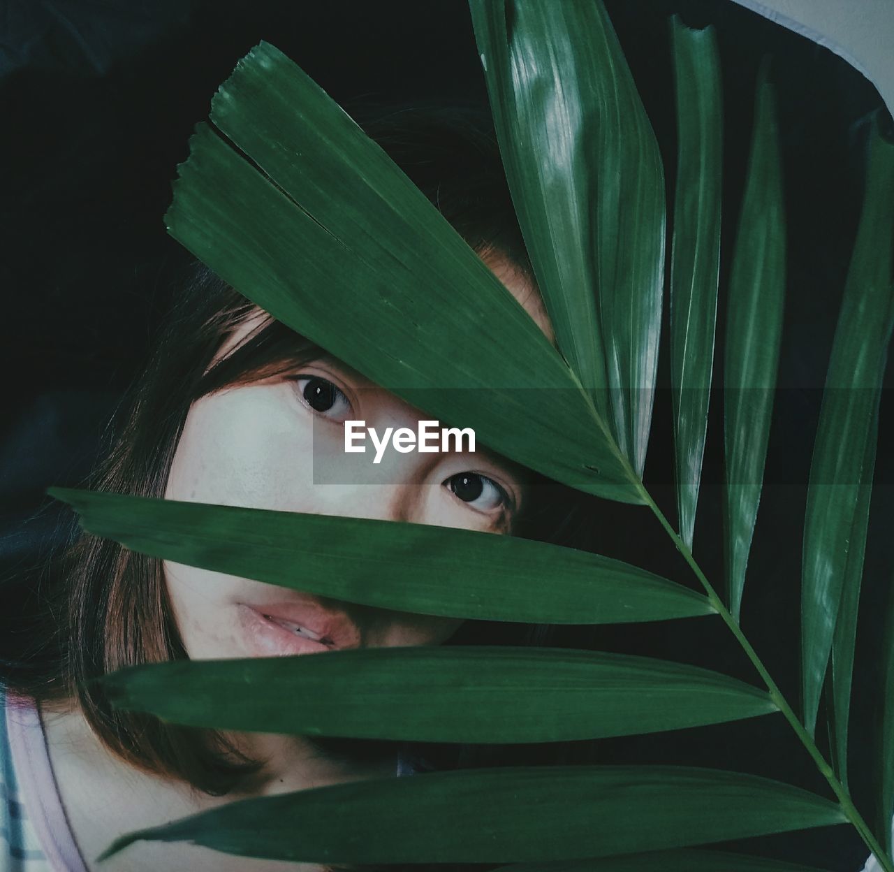 Close-up of thoughtful woman by leaves