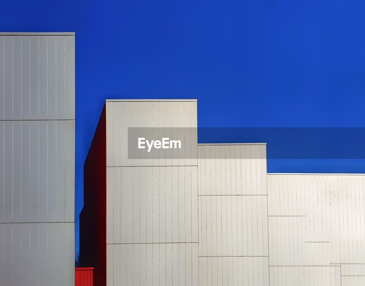 Close-up of white building against blue sky