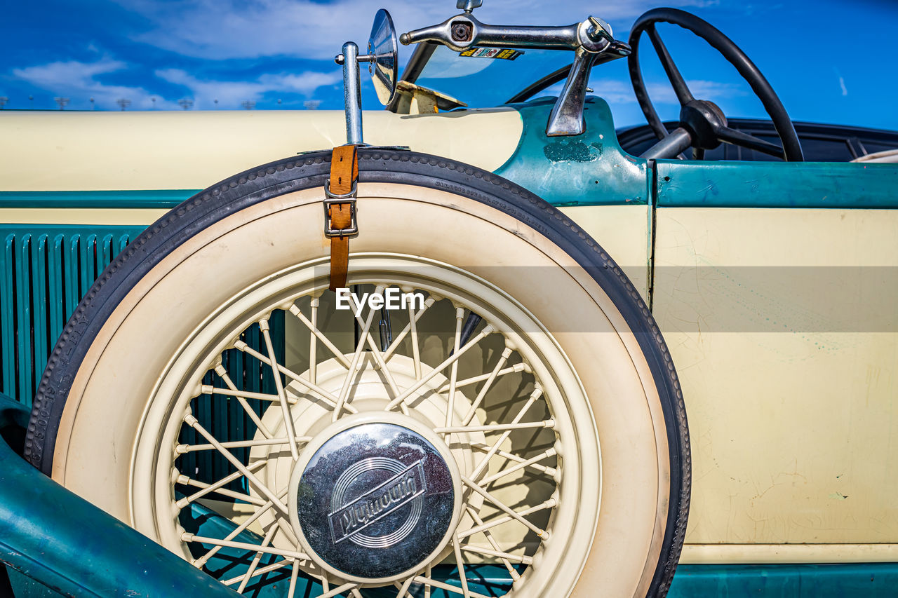 CLOSE-UP OF BICYCLE WHEEL AGAINST BLUE METAL