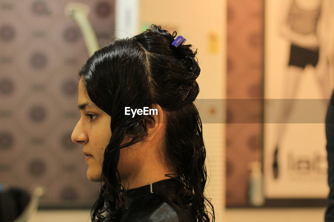 PORTRAIT OF A YOUNG WOMAN LOOKING AWAY OUTDOORS