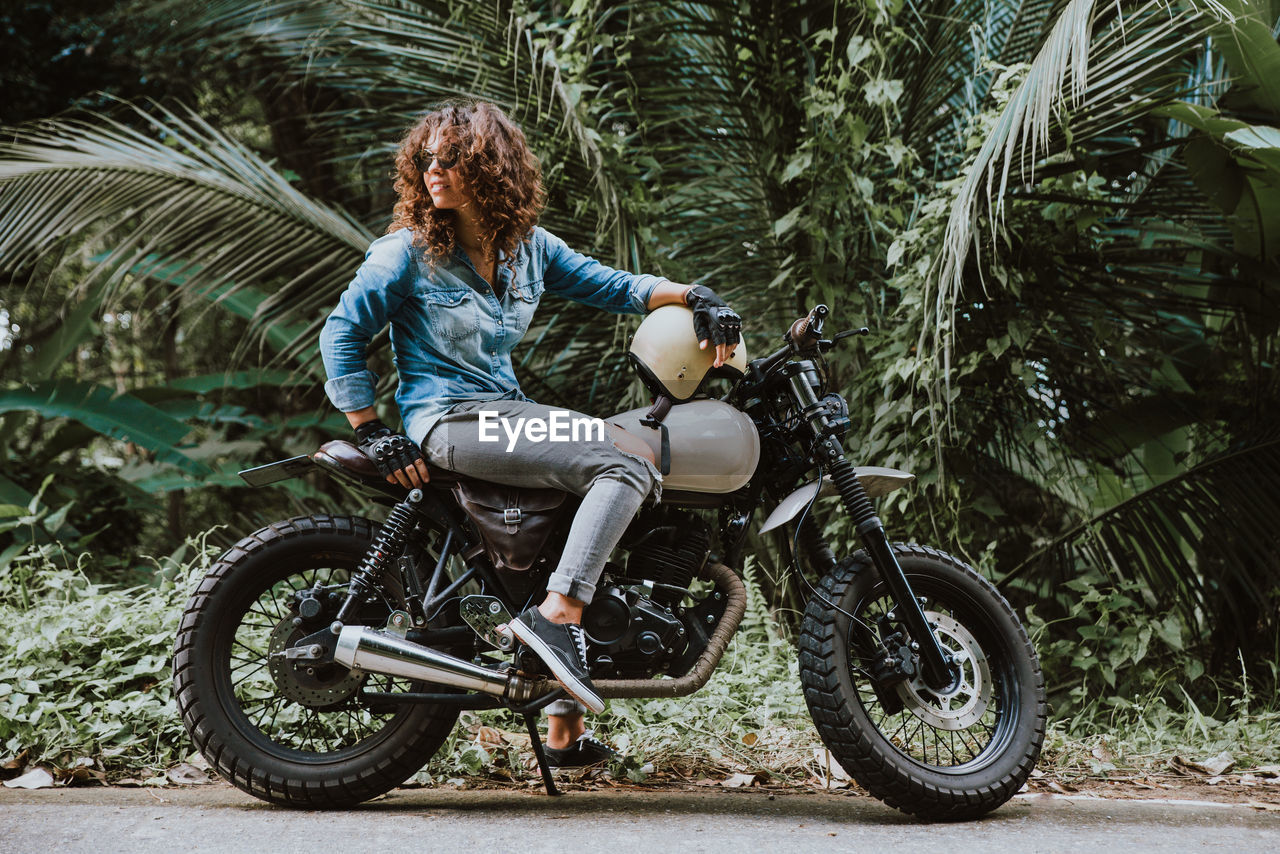 Woman looking away while sitting on motor cycle