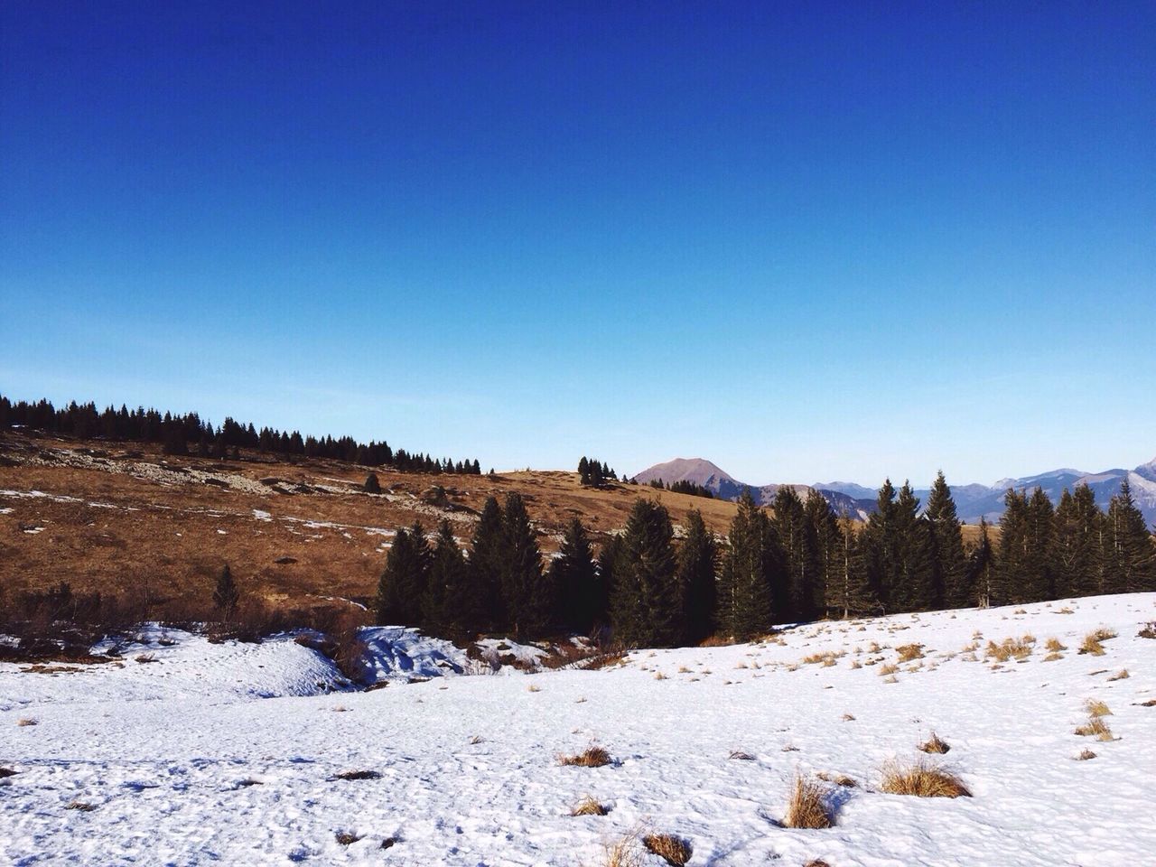 Scenic view of snow covered hill against clear sky