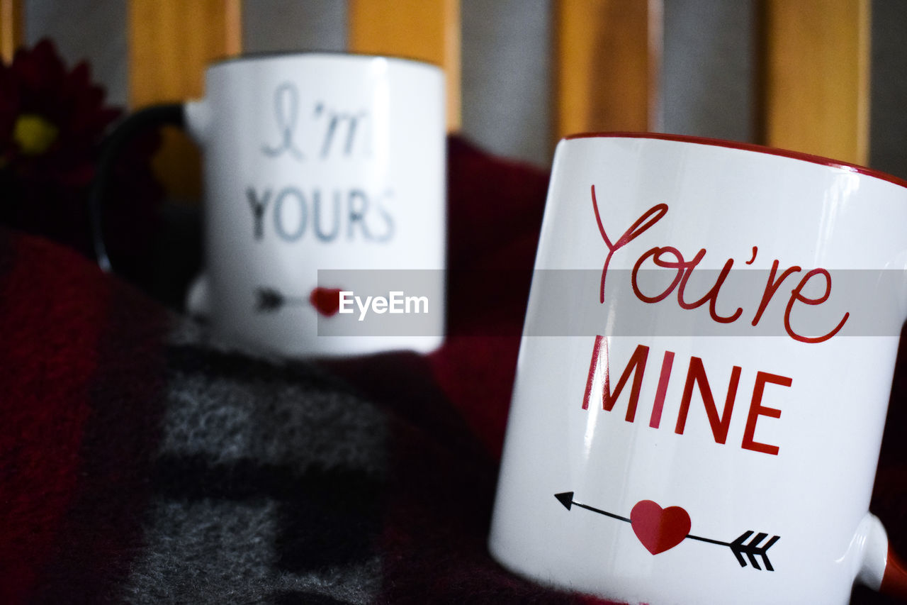 Close-up of mug with texts on blanket