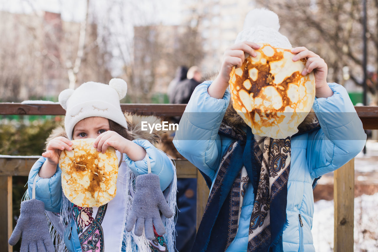 REAR VIEW OF PEOPLE HOLDING ICE CREAM