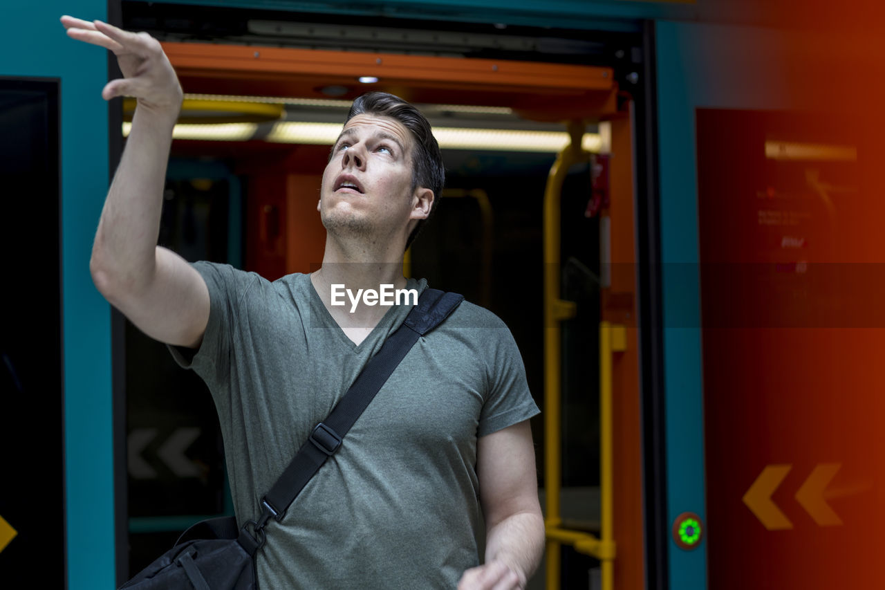 Young man with basketball standing at train entrance