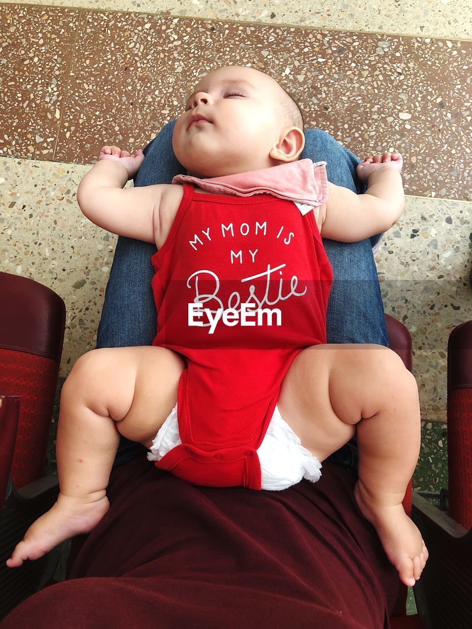 Midsection of woman with toddler sitting on chair