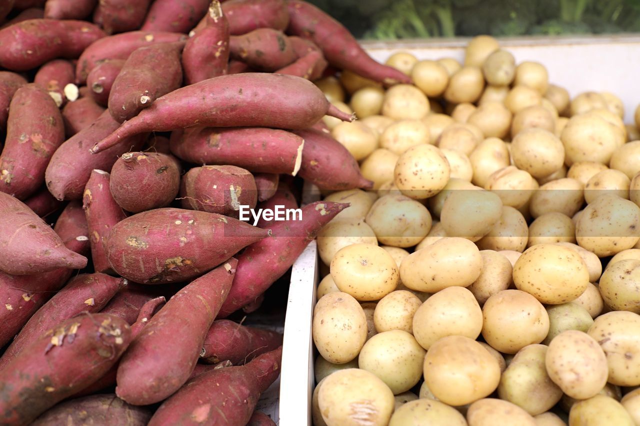 Close-up of russet and sweet potatoes yams for sale at market stall