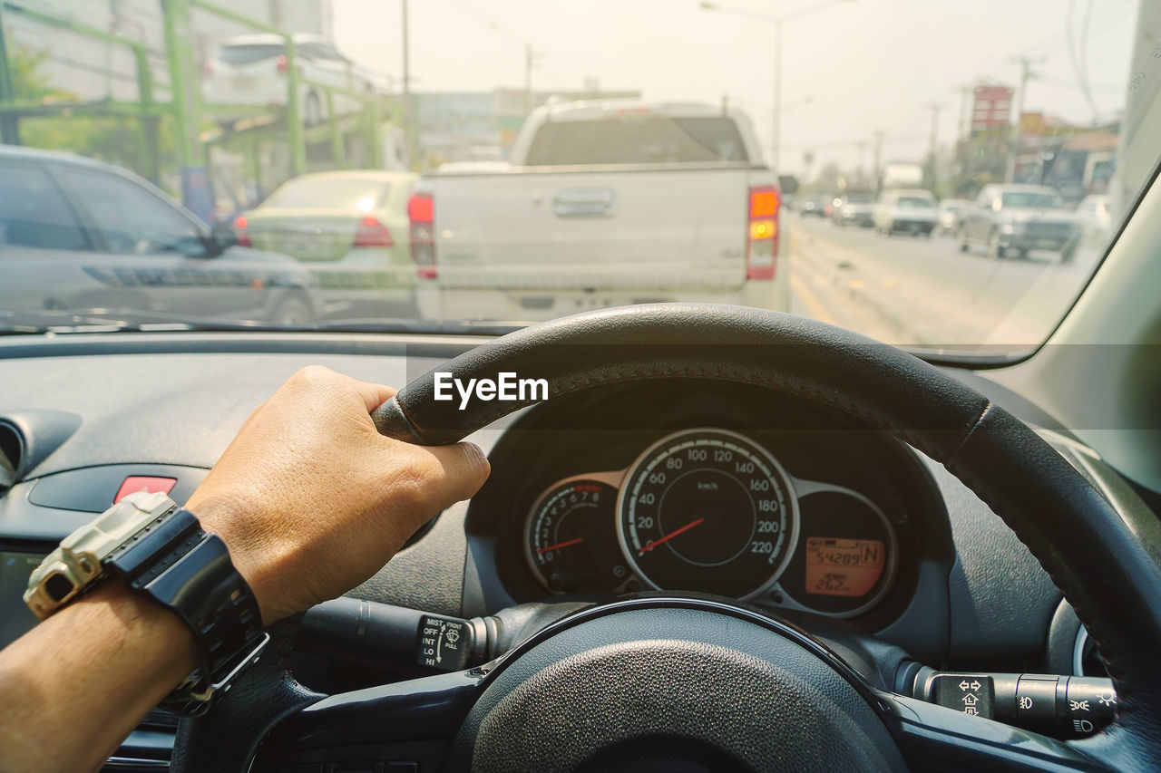 Close-up of hand driving car