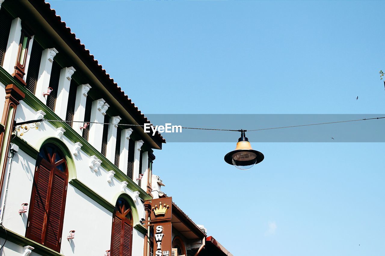 Low angle view of street lamp hanging against clear sky