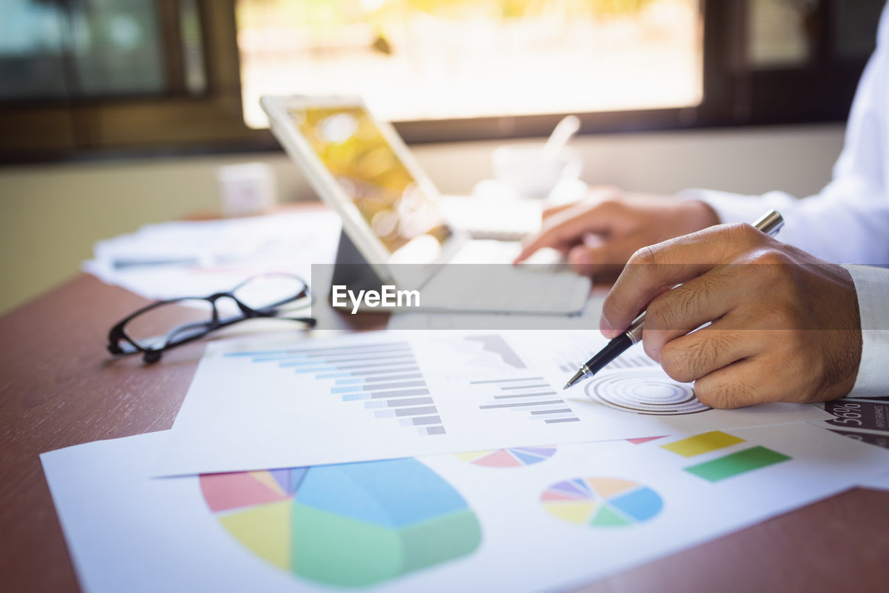 Cropped image of businessman analyzing graph in office