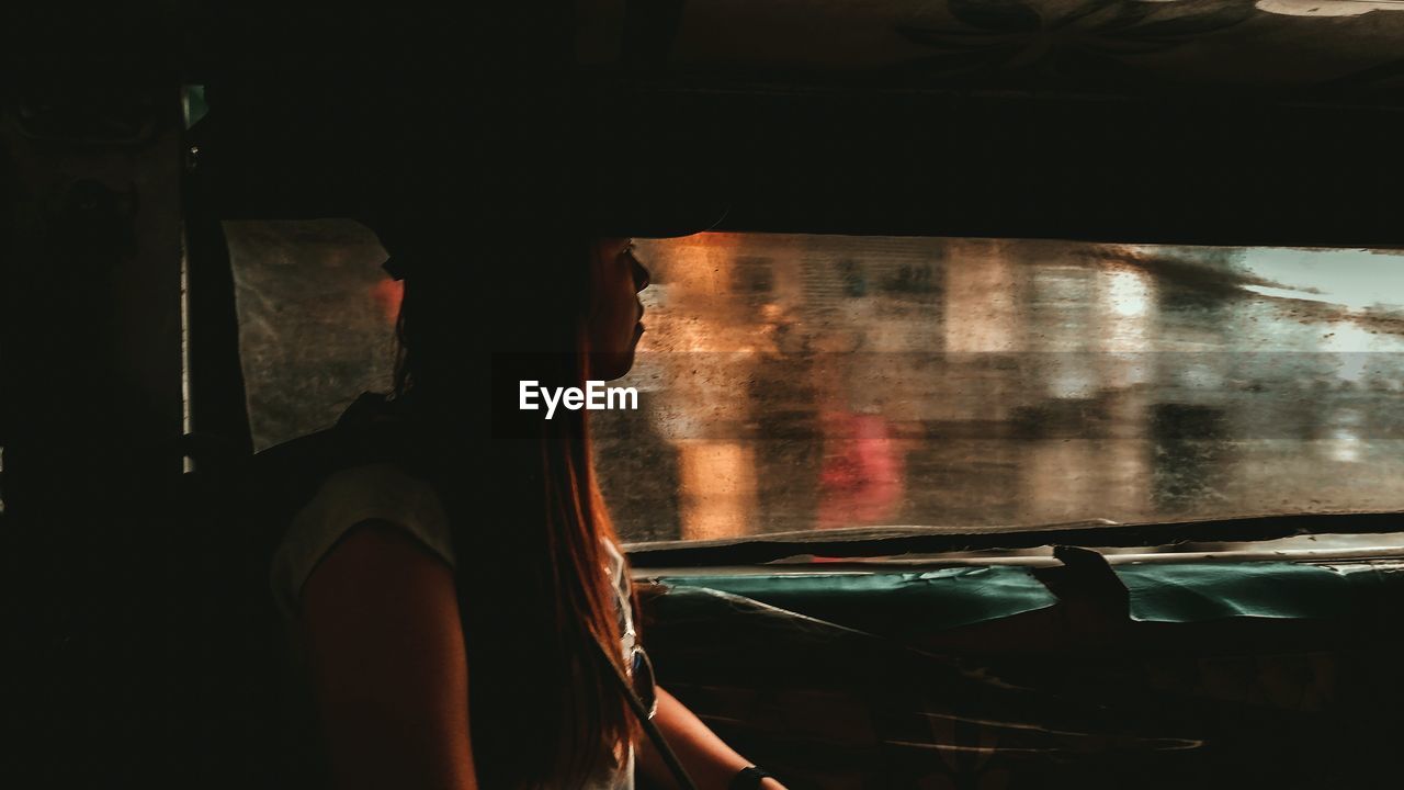 Side view of woman sitting in car