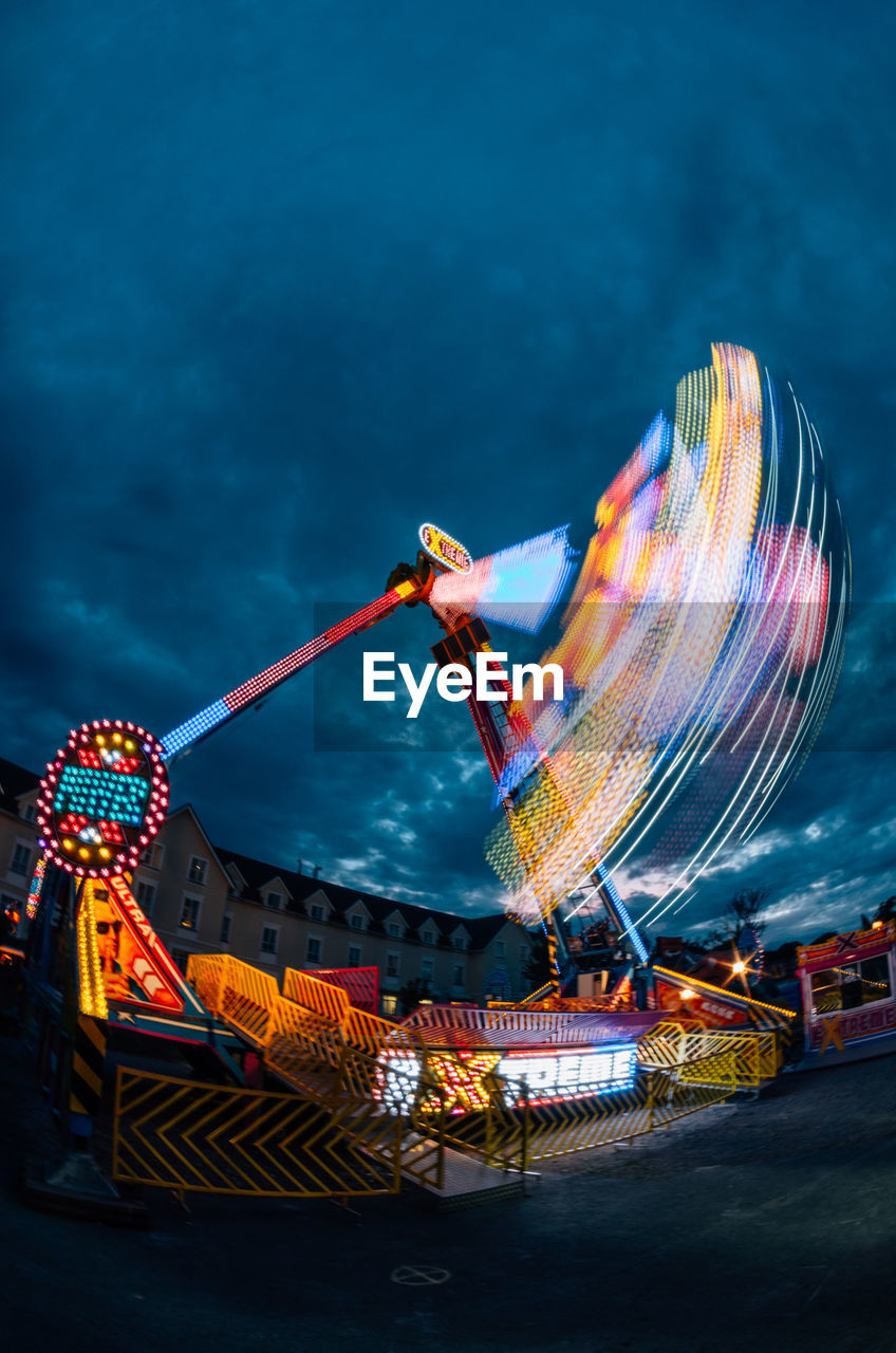 Illuminated ferris wheel against sky at night