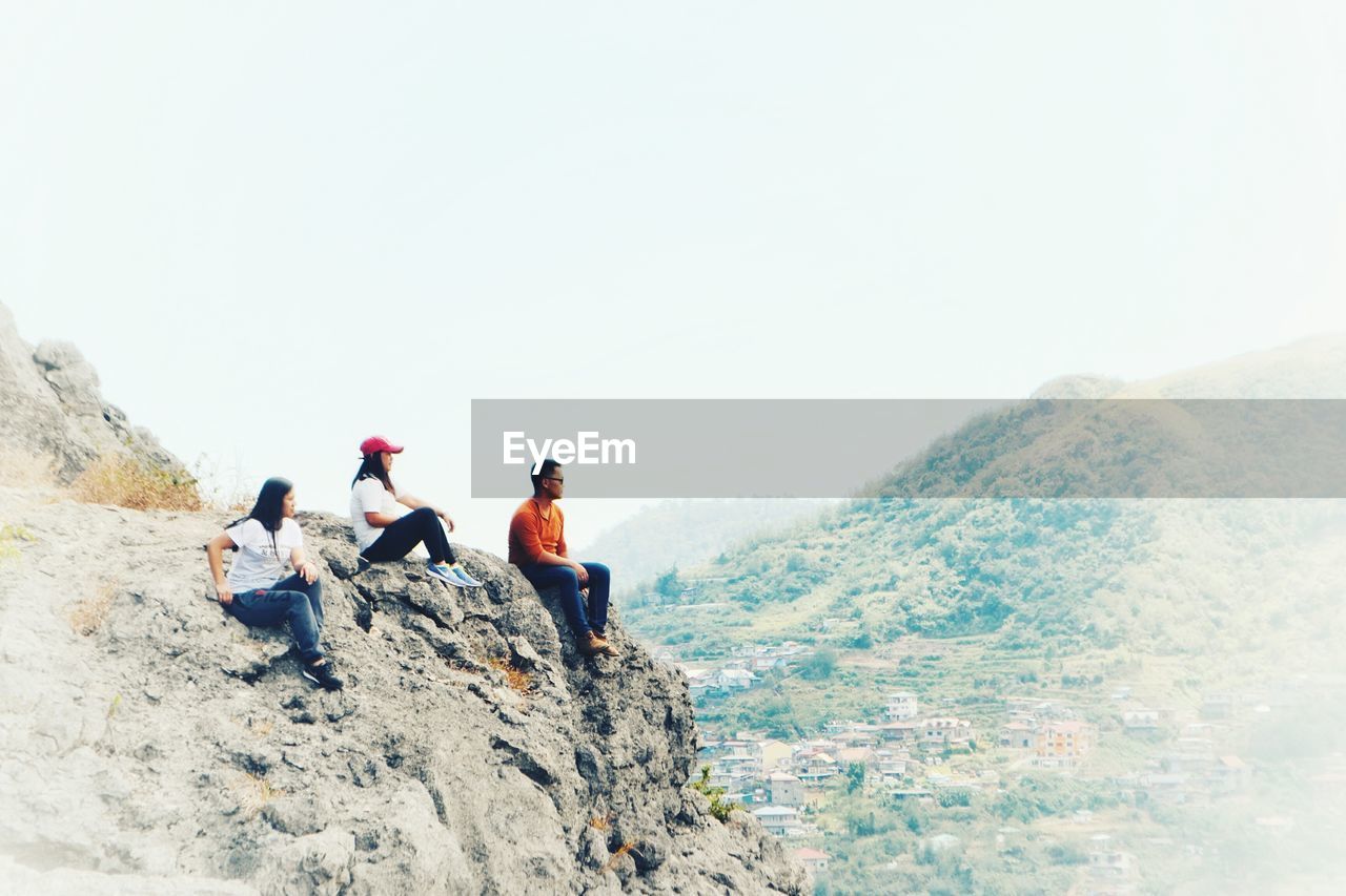 PEOPLE ON MOUNTAIN AGAINST SKY