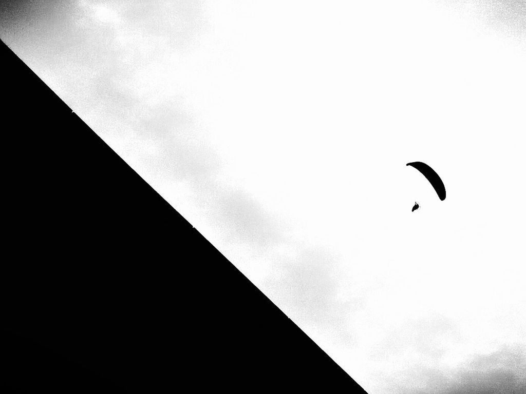 Low angle view of person paragliding in sky