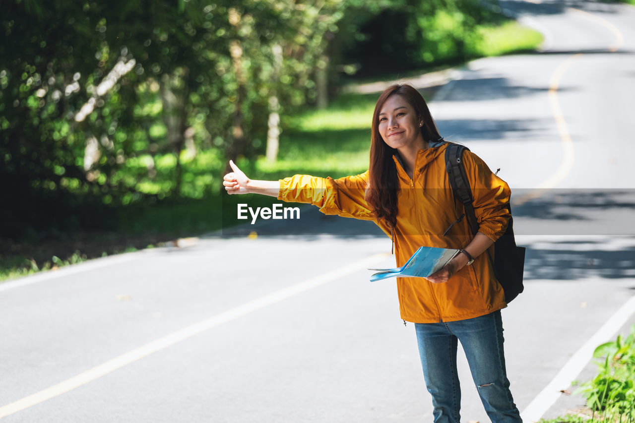 Portrait of young woman walking on road