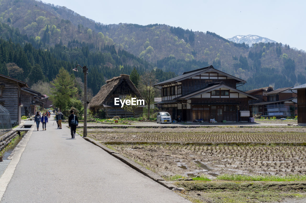 People walking on road mountain against sky