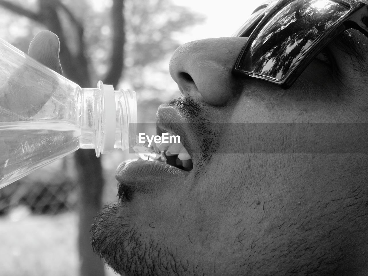 Close-up of man drinking water from bottle