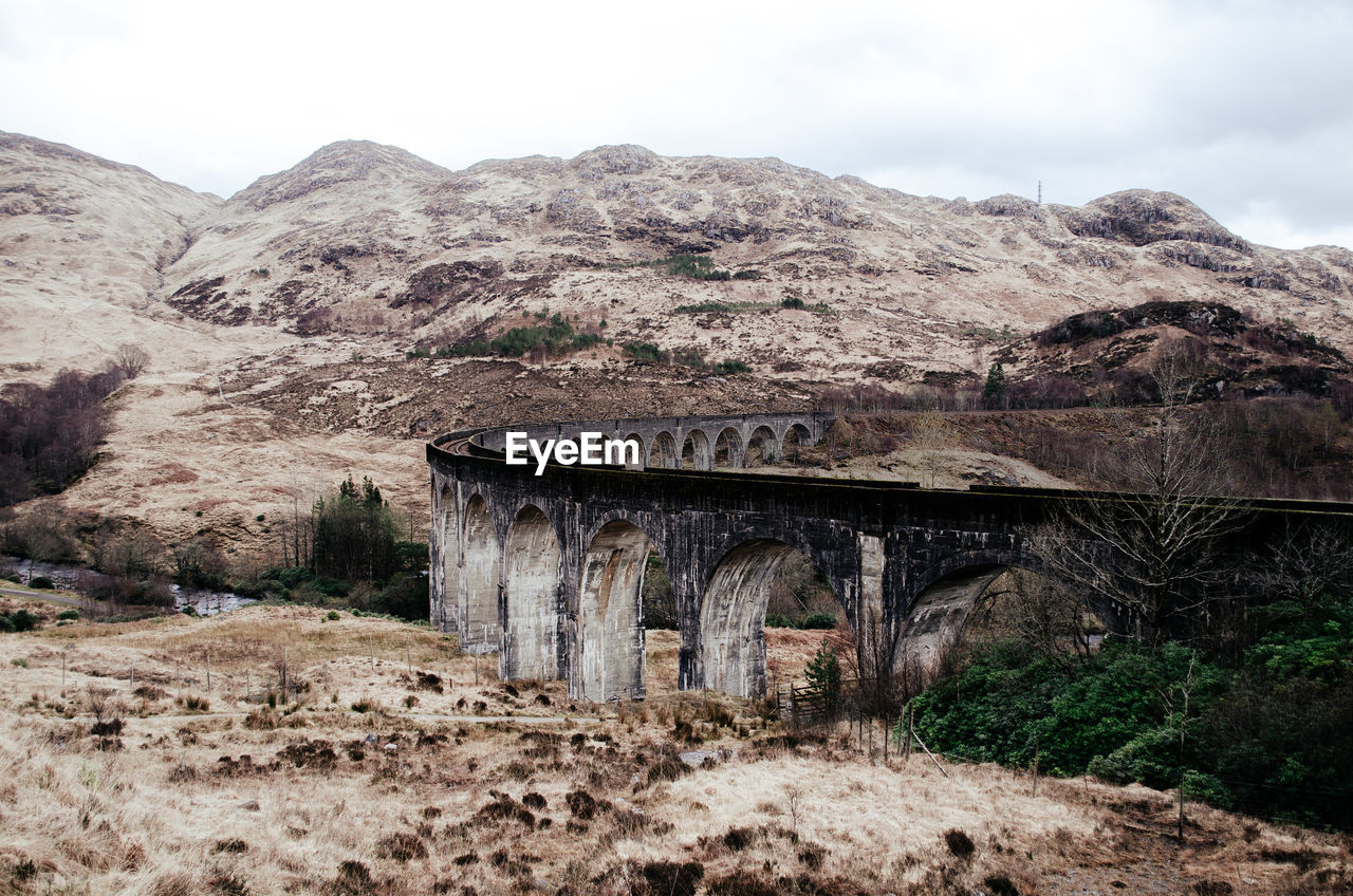 Old train bridge against rock mountain