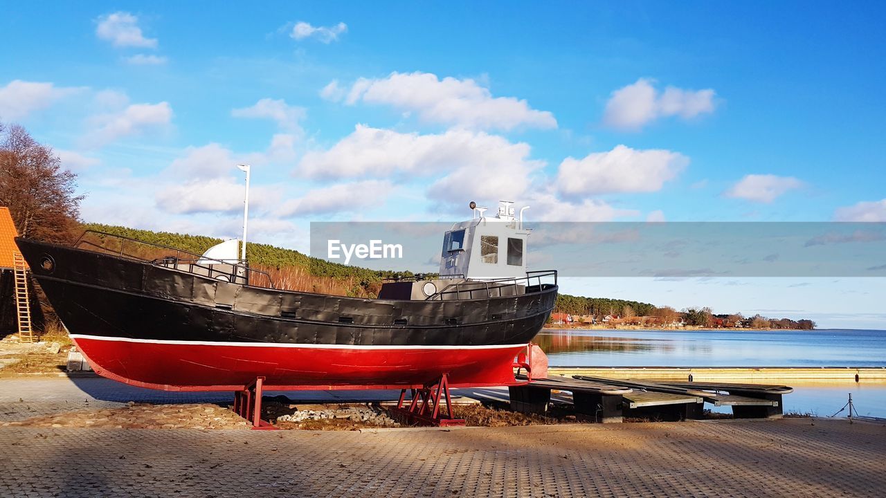 Boats moored on pier by sea against sky