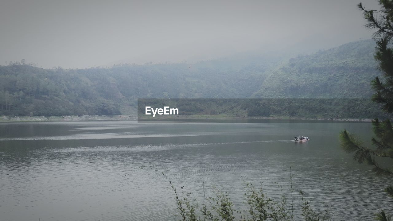 SCENIC VIEW OF LAKE BY MOUNTAIN AGAINST SKY